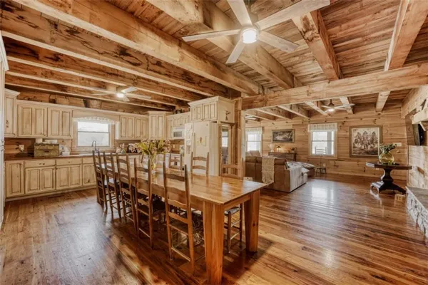 a room with lots of wooden furniture and stainless steel appliances