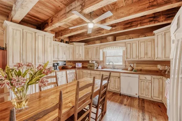 a kitchen with stainless steel appliances a stove a sink and white cabinets with wooden floor