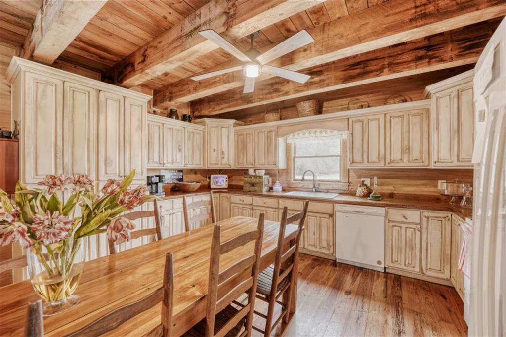 226 Vinson Mountain Road Rockmart, GA 30153 - Photo 13 of 35 a kitchen with stainless steel appliances a stove a sink and white cabinets with wooden floor