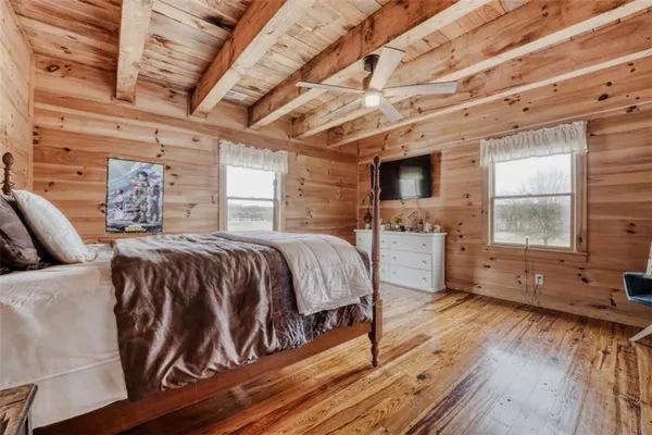 a bed sitting in a spacious bedroom next to a window