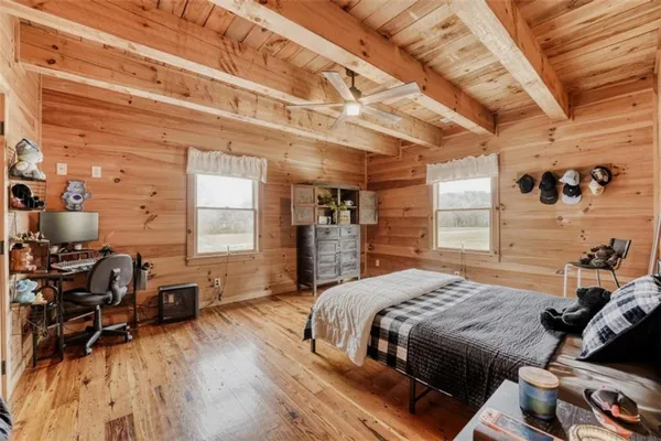 a bedroom with a bed next to a window with chair and table