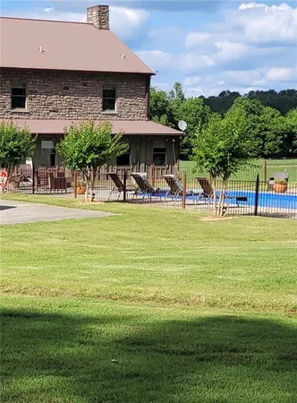 a view of a swimming pool with lawn chairs under an umbrella
