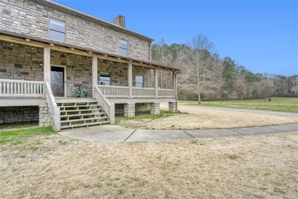 a view of a house with a yard and wooden fence