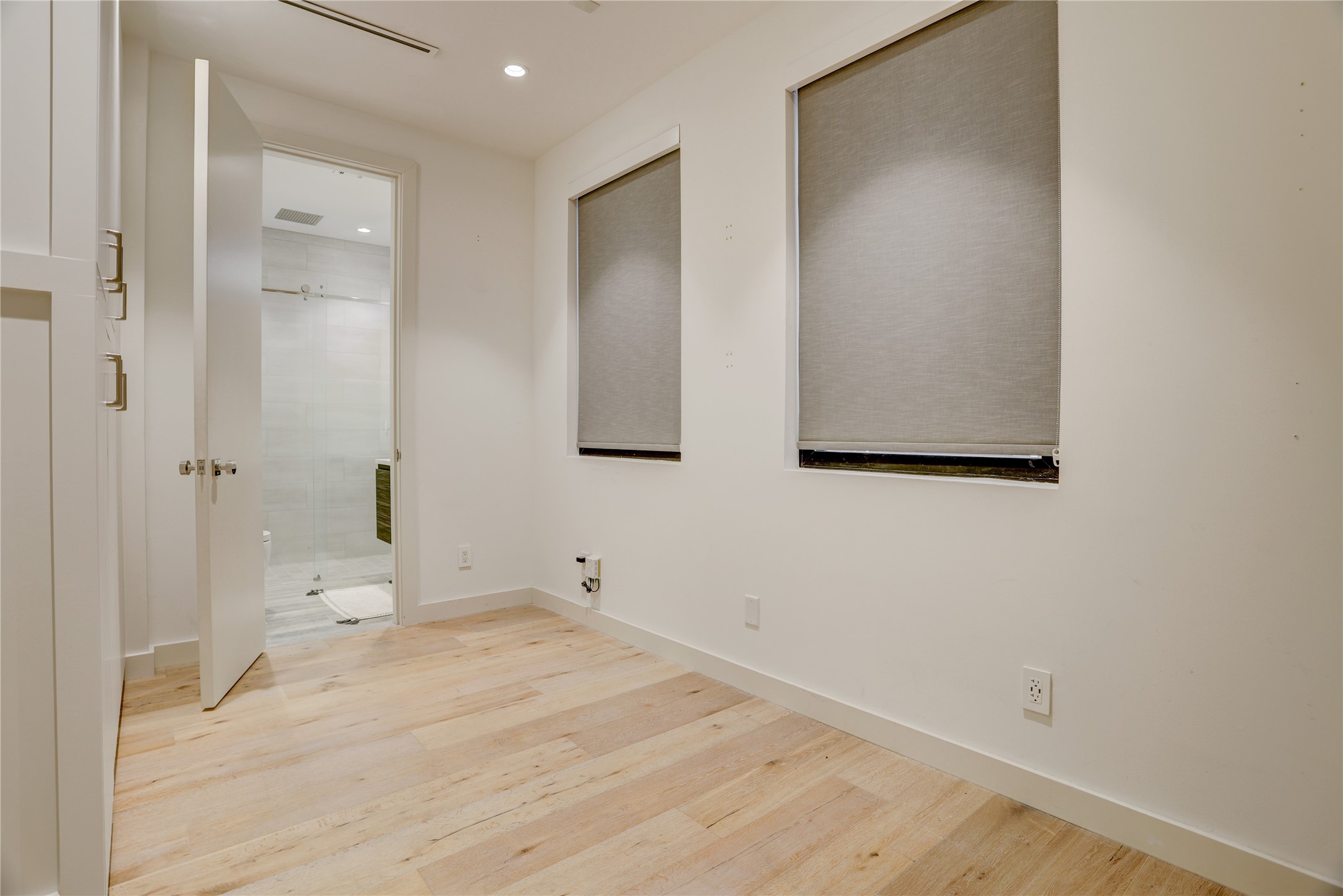 1807 Indiana Street Houston, TX 77006 - Photo 2 of 35 Office / Bonus Bedroom: Versatile first-floor space ideal for a home office, gym, or guest suite, featuring wide-plank wood flooring, recessed lighting, premium roller shades, and an attached en-suite bath.