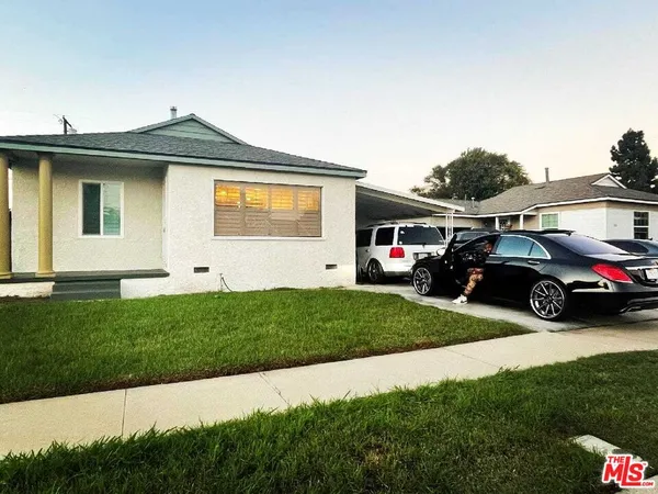 a front view of a house with a garden and parking space