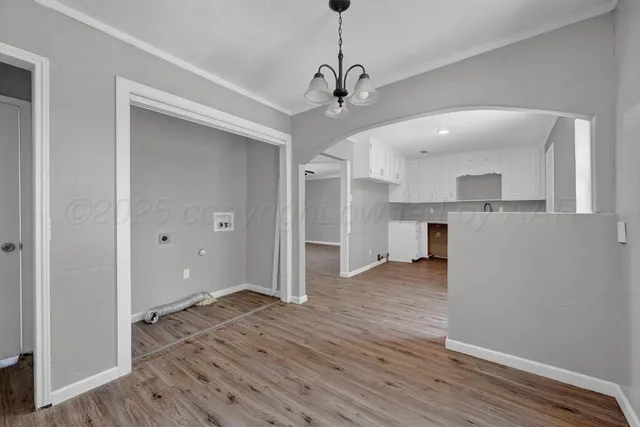an empty room with wooden floor ceiling fan and windows