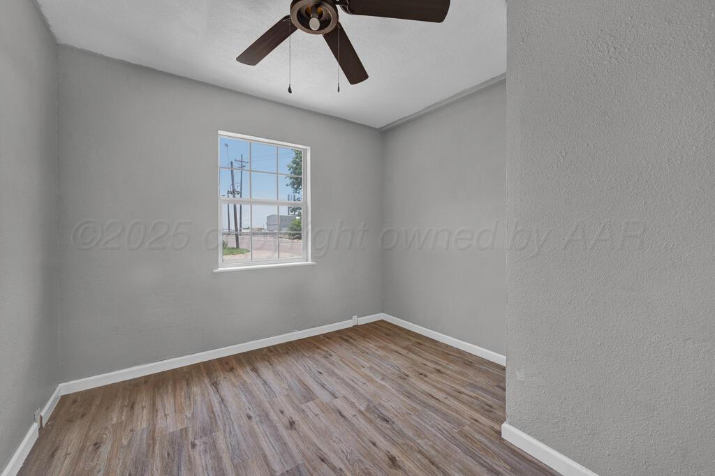 4360 South Polk Street Amarillo, TX 79110 - Photo 17 of 20 a view of empty room with wooden floor and fan