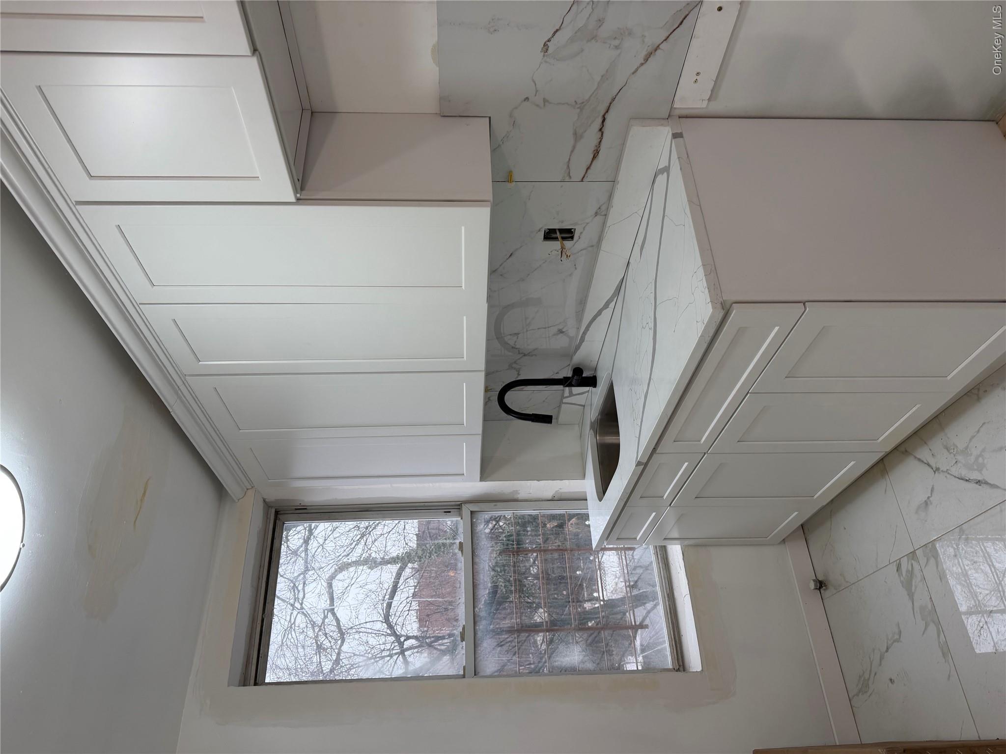70 Howard Avenue Brooklyn, NY 11221 - Photo 3 of 8 a kitchen with a sink cabinets and window
