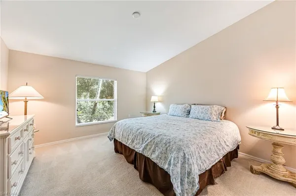 a bedroom with a bed lamp and a window