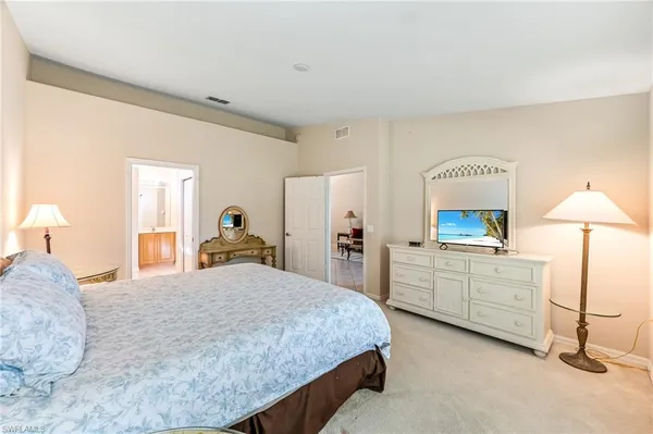 a large bedroom with a bed and a desk