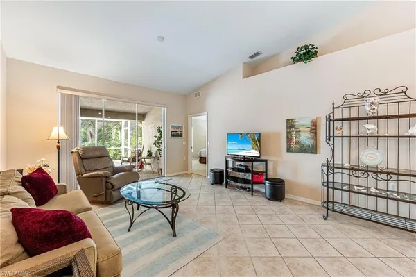 a living room with furniture a flat screen tv and a large window