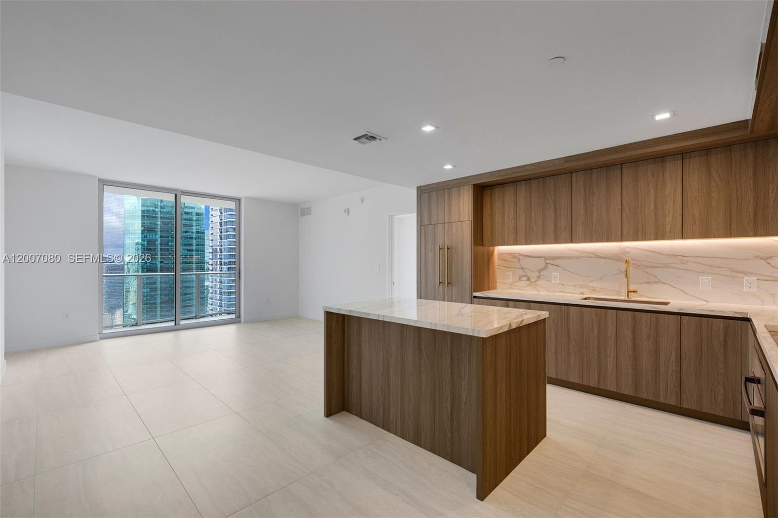 77 Southeast 5th Street, Unit PH01 Miami, FL 33131 - Photo 17 of 31 a kitchen with stainless steel appliances a large counter top a refrigerator and a sink