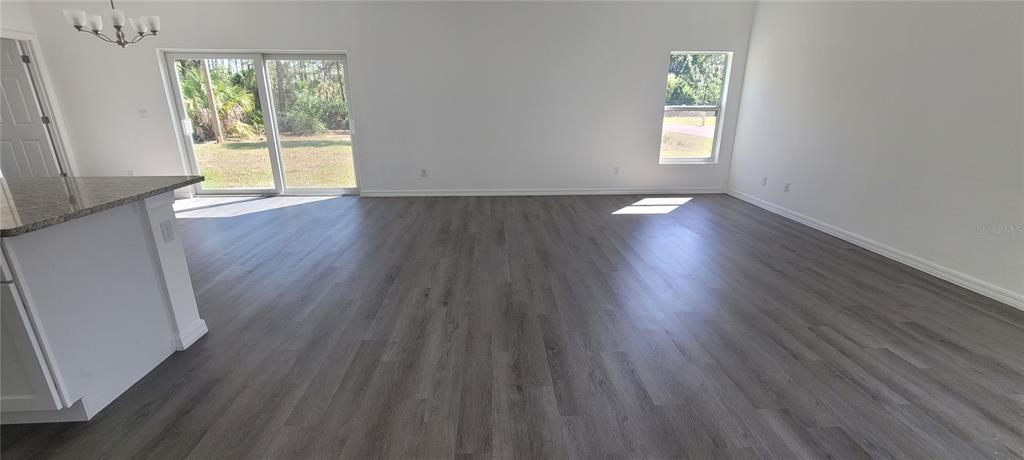 273 Santa Martia Street Southwest Palm Bay, FL 32908 - Photo 5 of 12 a view of an empty room with wooden floor and a window