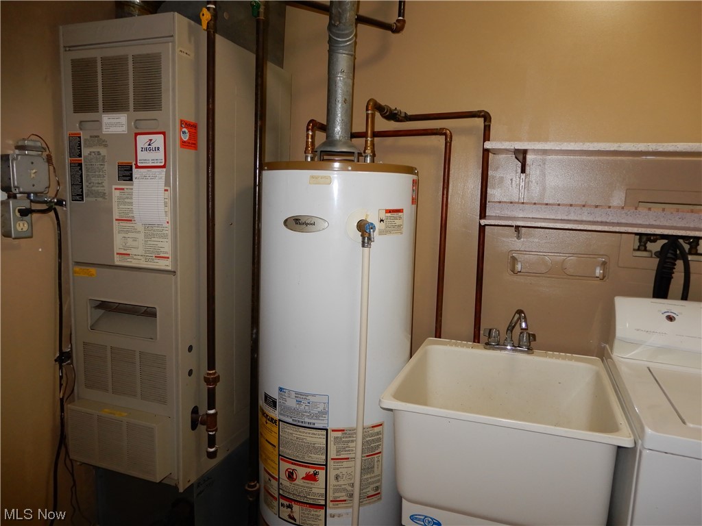 1168 Dock Road Madison, OH 44057 - Photo 20 of 35 Utility room featuring heating utilities, washer and clothes dryer, gas water heater, and sink