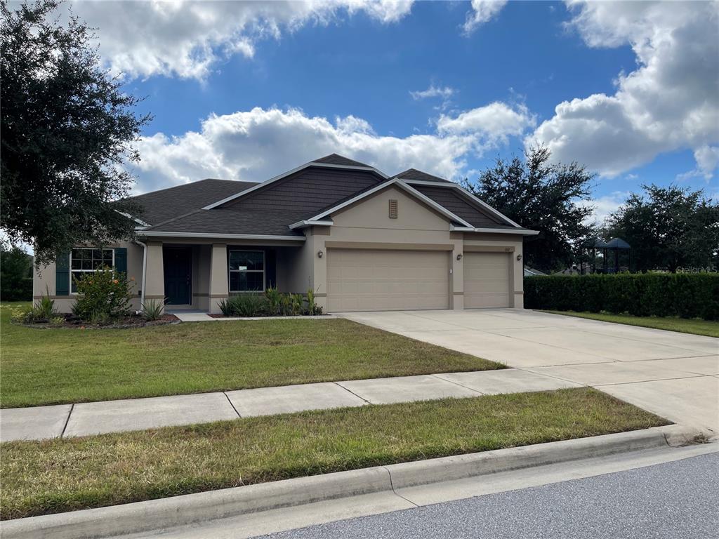 1312 Ralph Poe Drive Apopka, FL 32703 - Photo 2 of 14 a front view of a house with a garden
