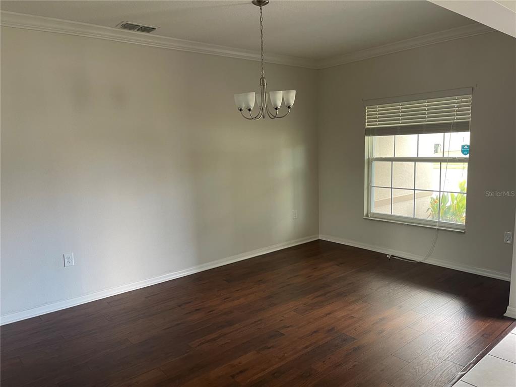 1312 Ralph Poe Drive Apopka, FL 32703 - Photo 6 of 14 an empty room with wooden floor and windows