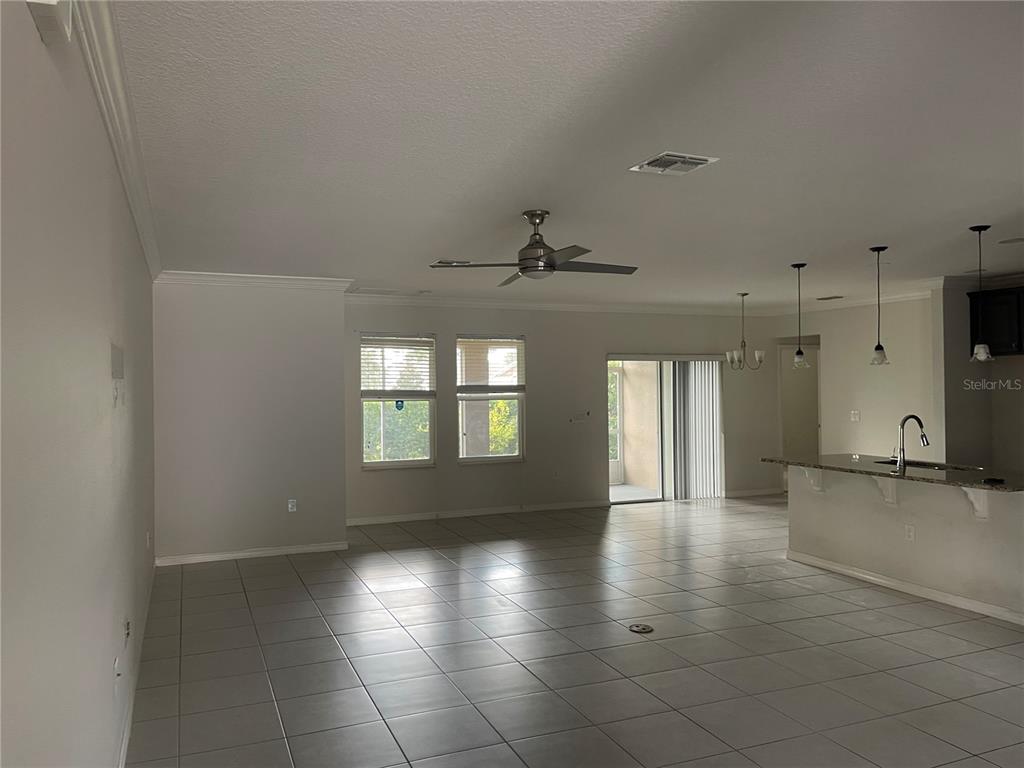 1312 Ralph Poe Drive Apopka, FL 32703 - Photo 7 of 14 an empty room with wooden floor and windows