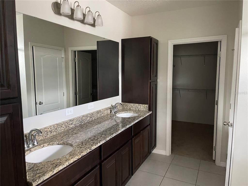 1312 Ralph Poe Drive Apopka, FL 32703 - Photo 10 of 14 a bathroom with a granite countertop sink and a mirror