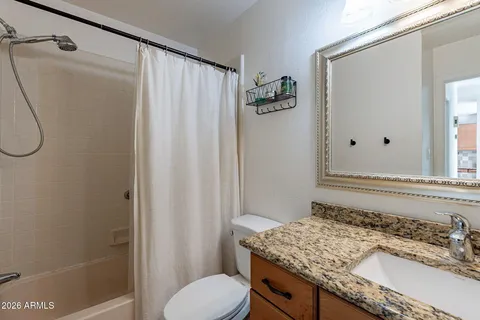 a bathroom with a granite countertop sink toilet and shower