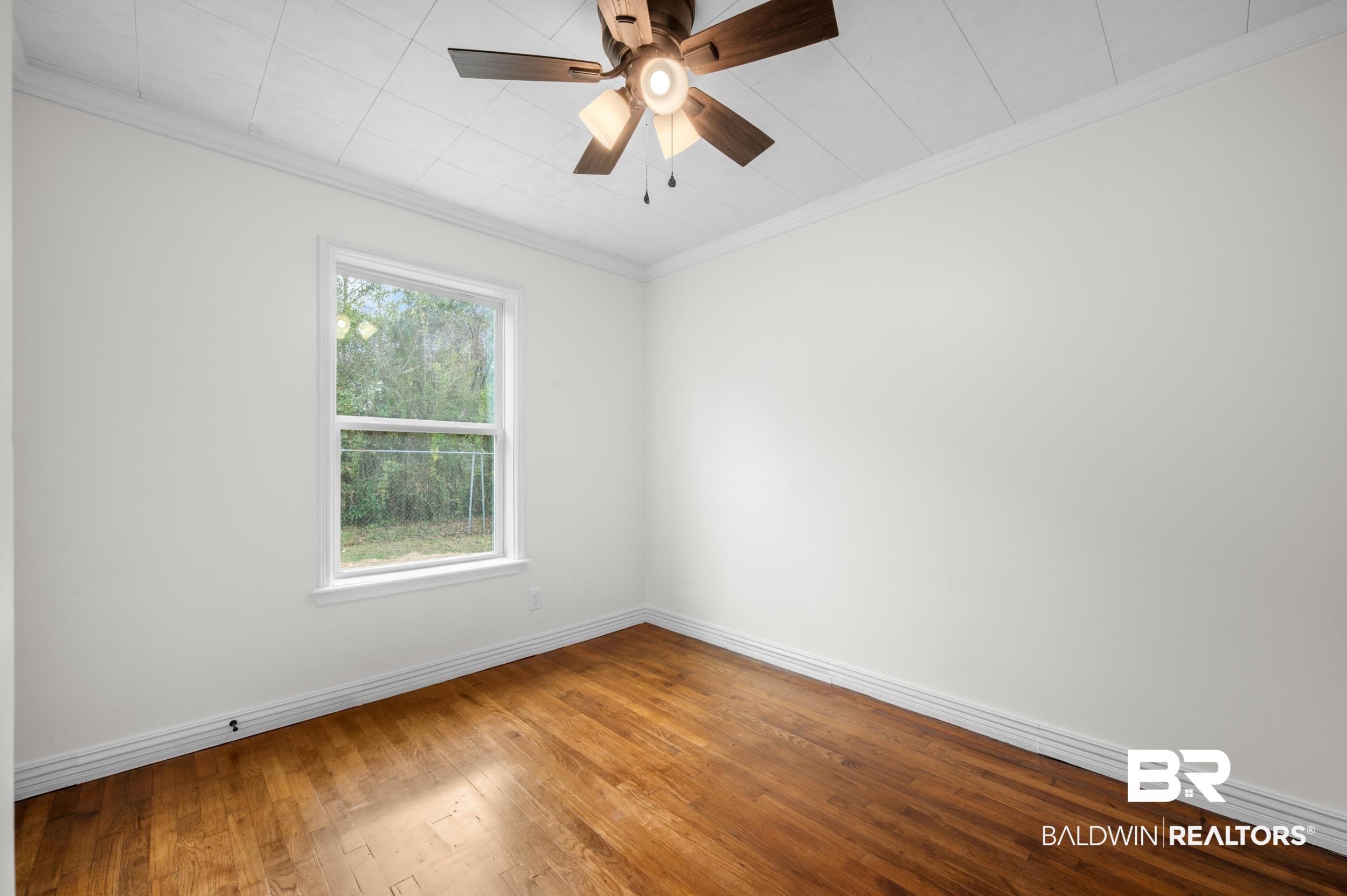 35780 Spring Road North Stapleton, AL 36578 - Photo 25 of 41 Spare room featuring ornamental molding, wood-type flooring, and ceiling fan