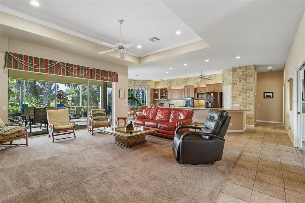 2116 Muskogee Trail Nokomis, FL 34275 - Photo 19 of 62 a living room with furniture a flat screen tv and floor to ceiling window