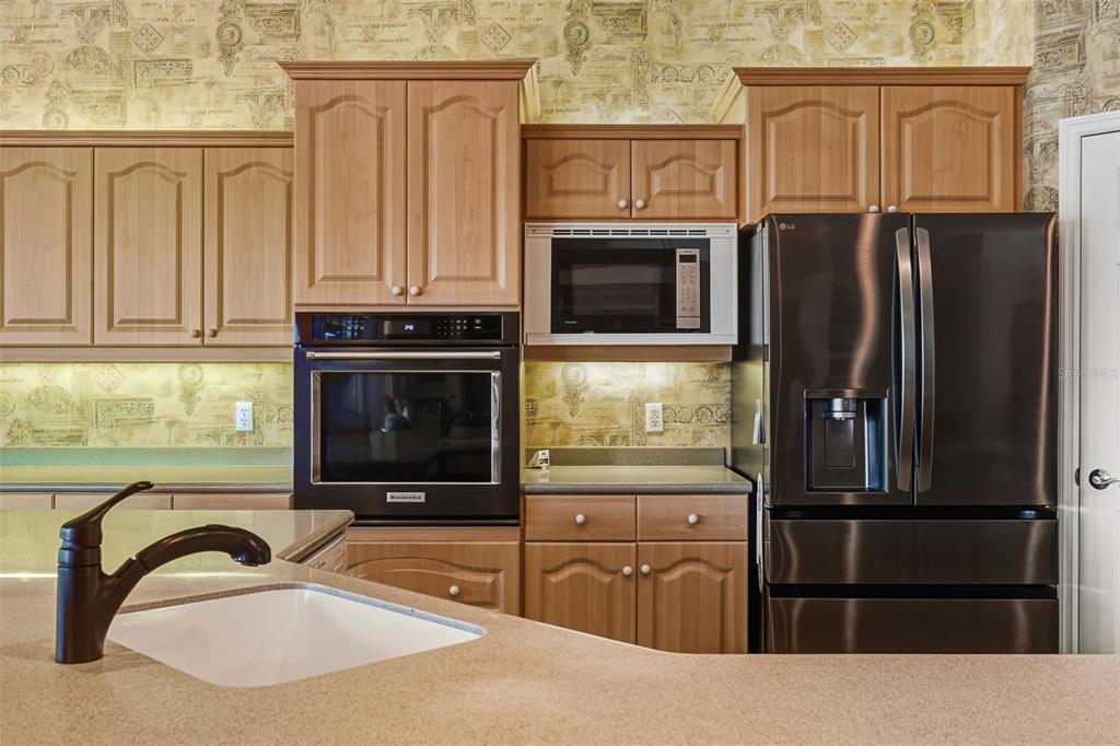 2116 Muskogee Trail Nokomis, FL 34275 - Photo 30 of 62 a kitchen with granite countertop a refrigerator and a stove top oven
