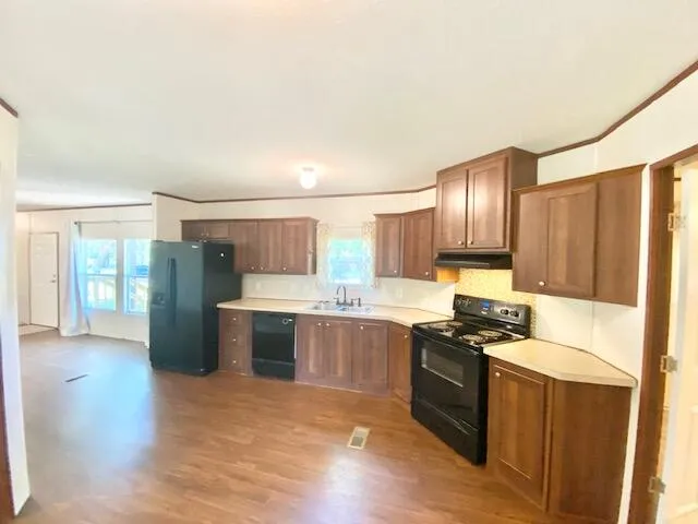 a kitchen with stainless steel appliances granite countertop a stove refrigerator and cabinets