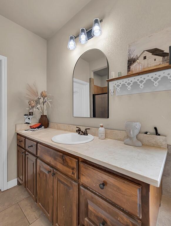 550 Hunton Lane Robinson, TX 76706 - Photo 19 of 35 Full bathroom with vanity, tile patterned flooring, and a shower with shower door
