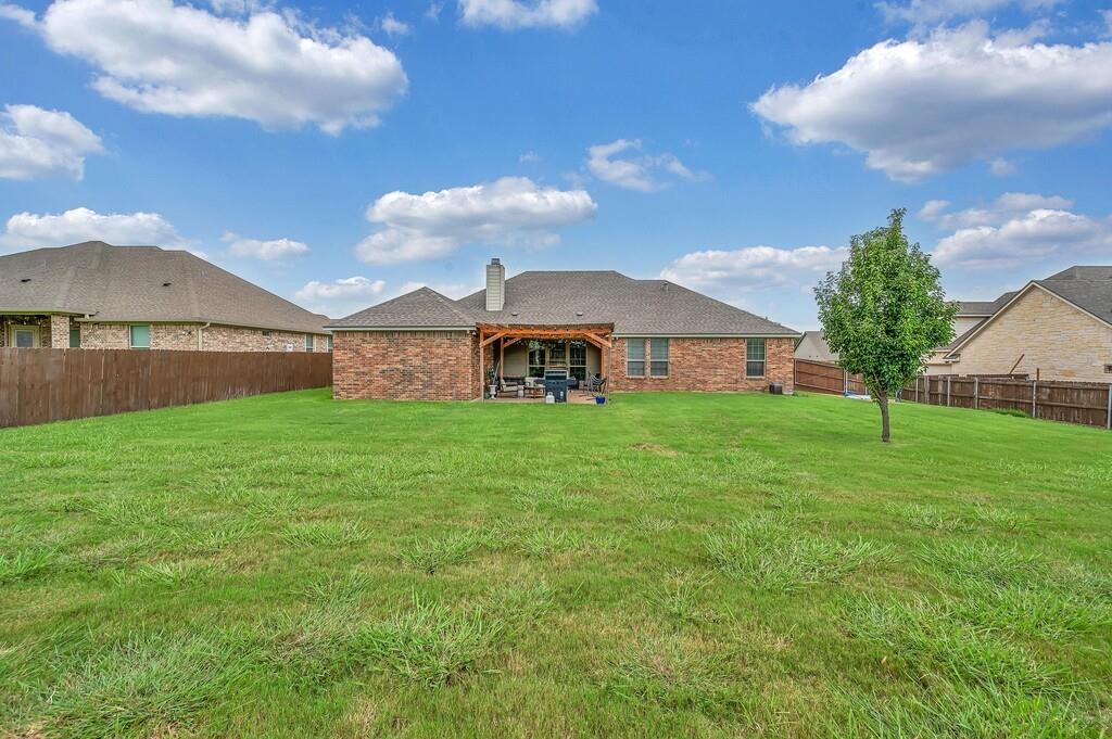 550 Hunton Lane Robinson, TX 76706 - Photo 32 of 35 Rear view of property with a fenced backyard, a chimney, brick siding, a patio area, and roof with shingles