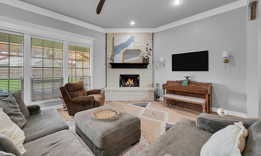 550 Hunton Lane Robinson, TX 76706 - Photo 6 of 35 Living area featuring crown molding, a stone fireplace, ceiling fan, recessed lighting, and wood finished floors