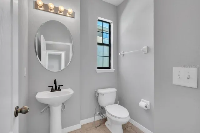 a bathroom with a toilet sink and mirror