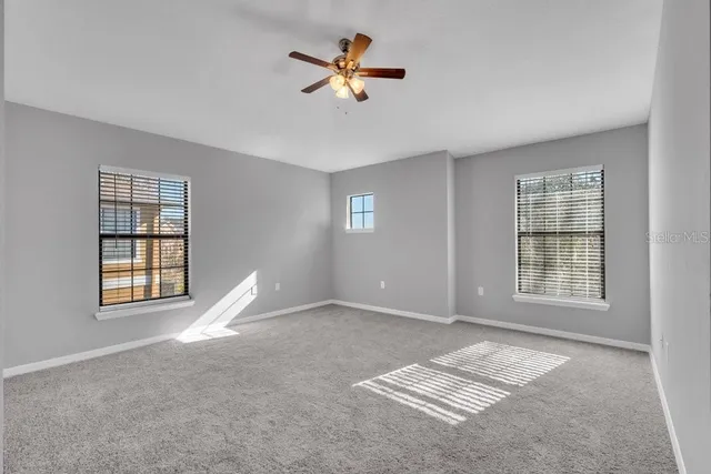 a view of wooden floor and a chandelier fan in a room