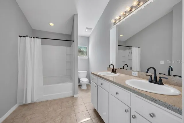 a bathroom with a double vanity sink mirror double and shower