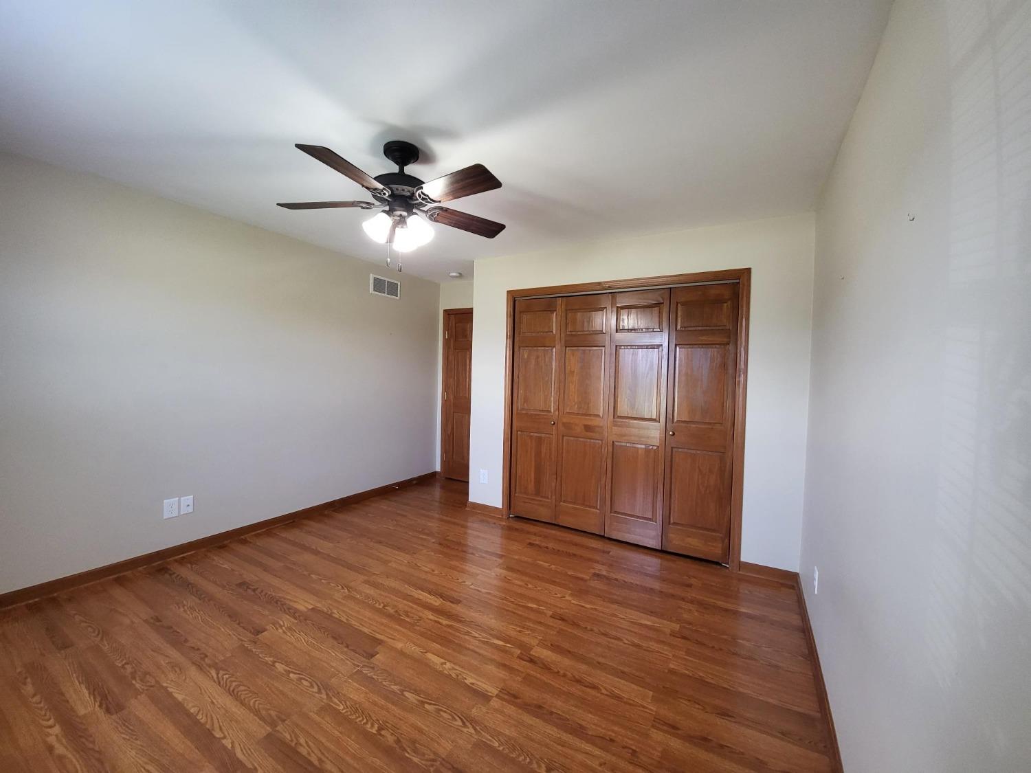 412 Juniper Street Northwest De Motte, IN 46310 - Photo 16 of 23 a view of an empty room with a ceiling fan and wooden floor