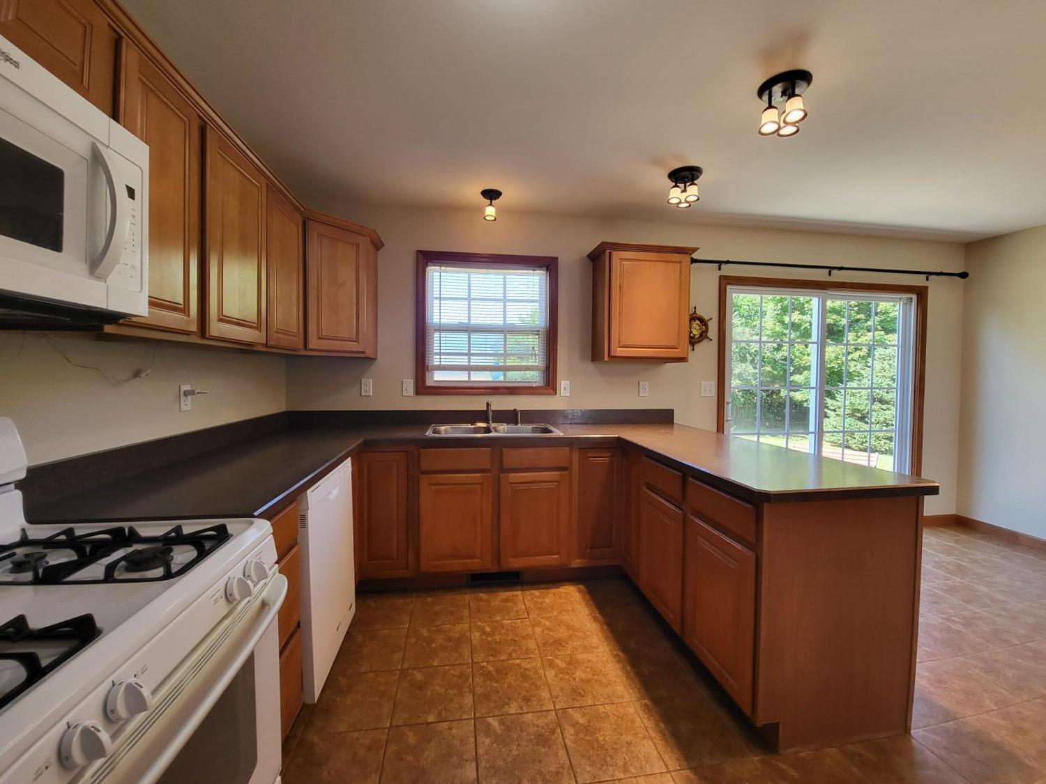 412 Juniper Street Northwest De Motte, IN 46310 - Photo 10 of 23 a kitchen with stainless steel appliances granite countertop a stove a sink and a microwave