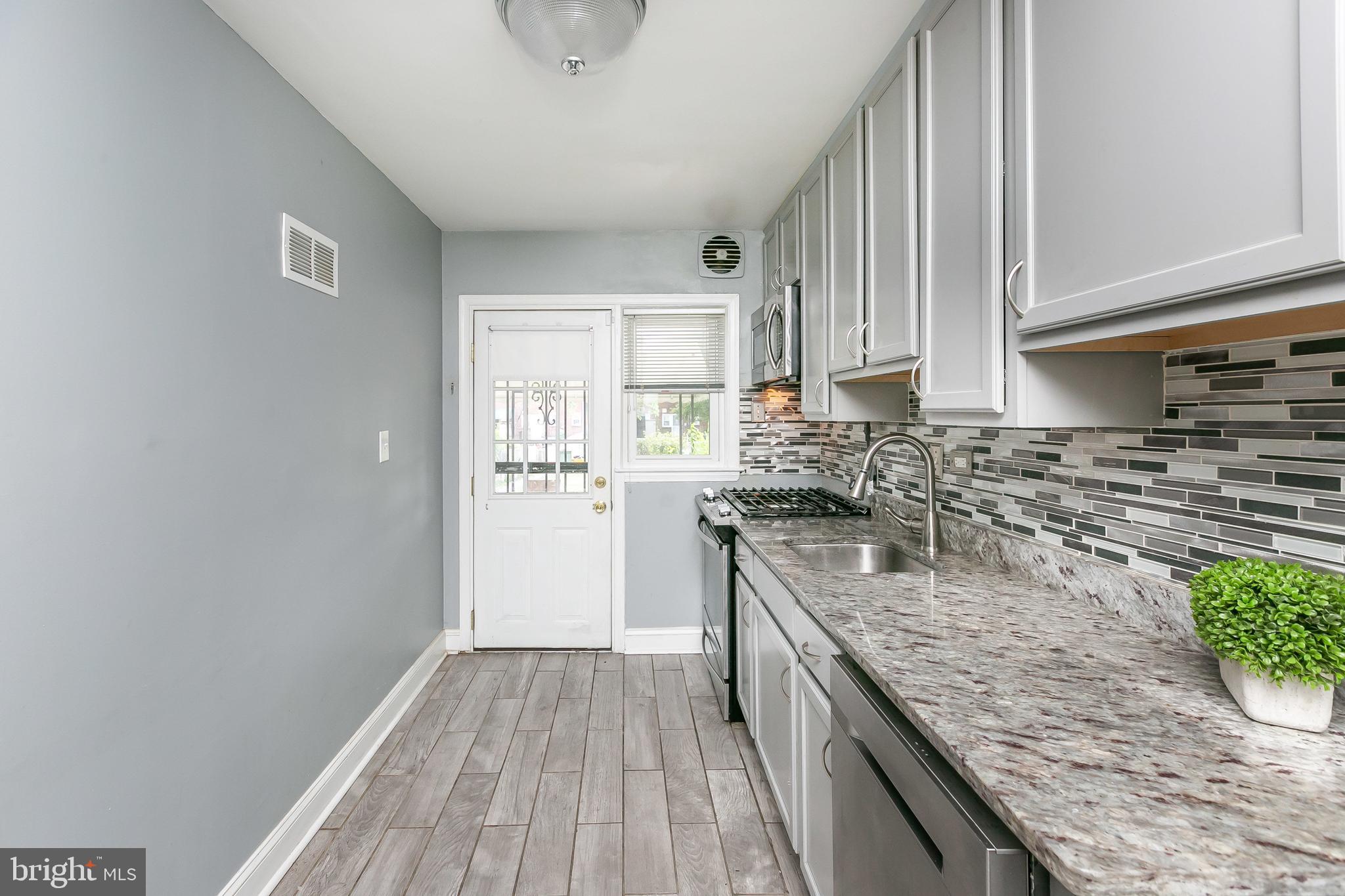 4921 St Gemma Road Baltimore, MD 21229 - Photo 11 of 33 a kitchen with stainless steel appliances granite countertop a sink stove and refrigerator