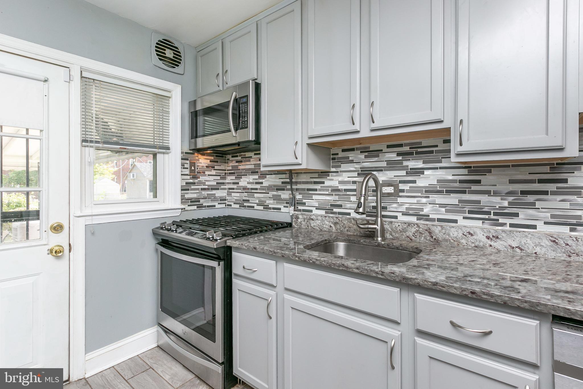4921 St Gemma Road Baltimore, MD 21229 - Photo 12 of 33 a kitchen with stainless steel appliances granite countertop a sink stove and microwave
