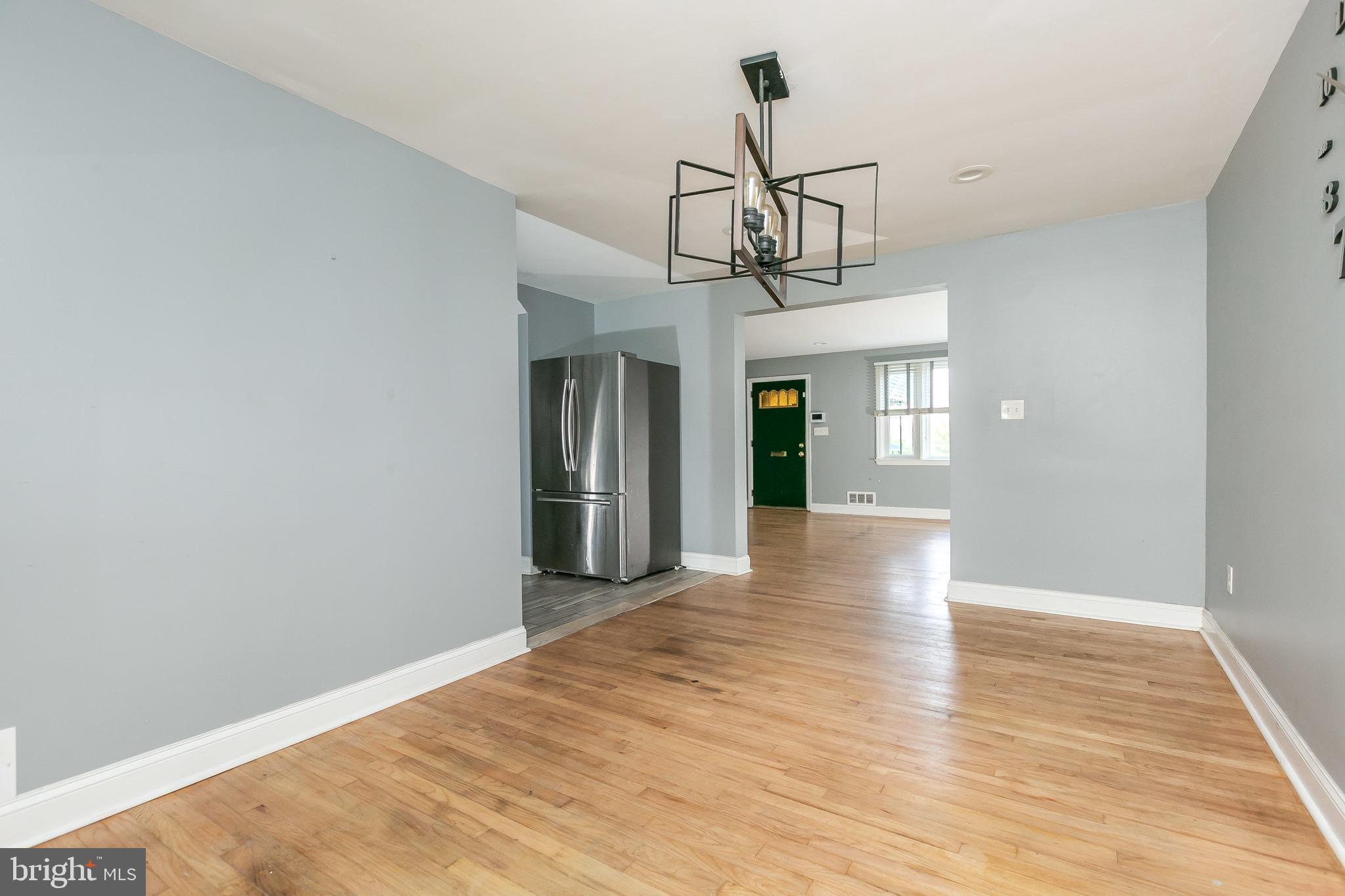 4921 St Gemma Road Baltimore, MD 21229 - Photo 7 of 33 a view of empty room with wooden floor and kitchen