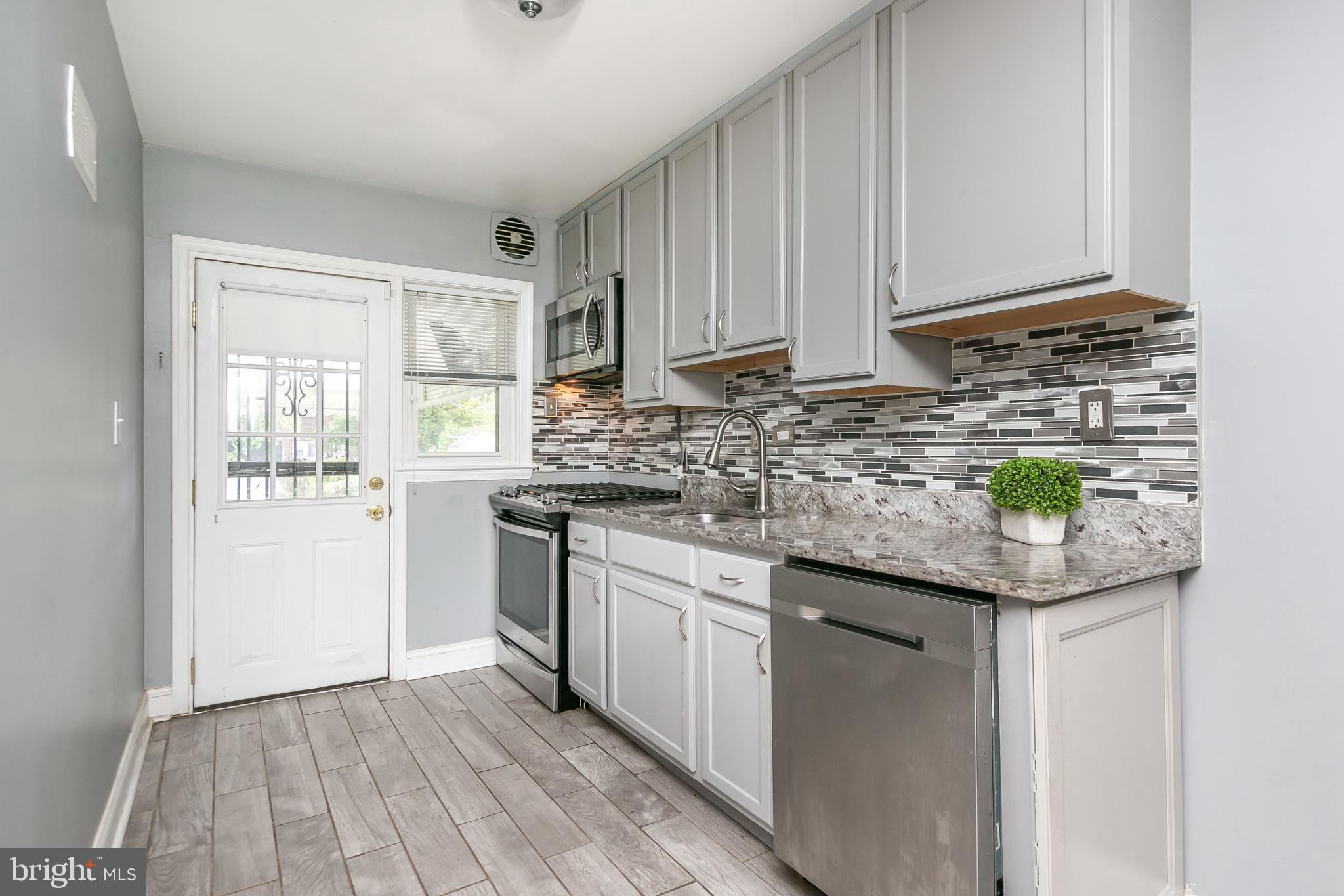 4921 St Gemma Road Baltimore, MD 21229 - Photo 10 of 33 a kitchen with stainless steel appliances granite countertop a sink and a white cabinets