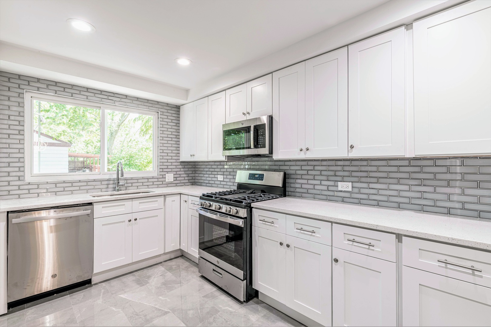 2845 Birch Road Homewood, IL 60430 - Photo 9 of 36 a kitchen with white cabinets appliances a sink and a window