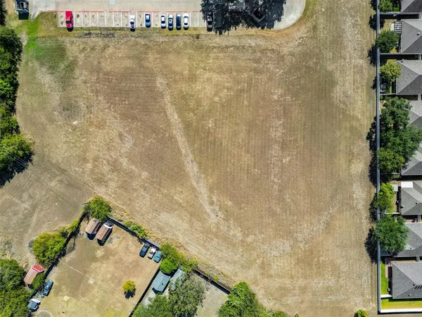 an aerial view of a house with a yard and mountain view in back