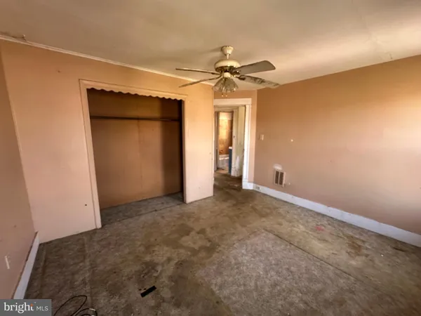 an empty room with a ceiling fan and a window