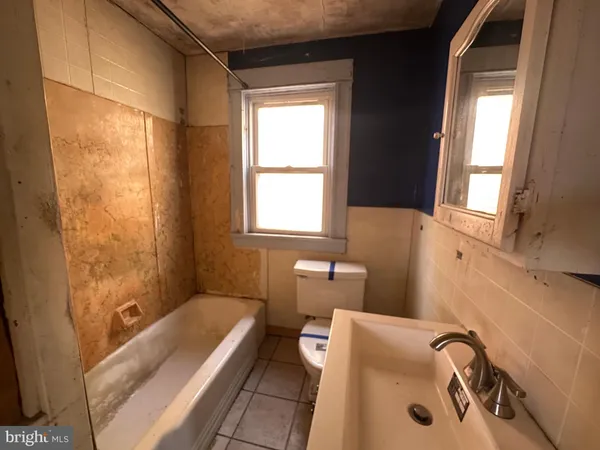a bathroom with a tub a sink and a window