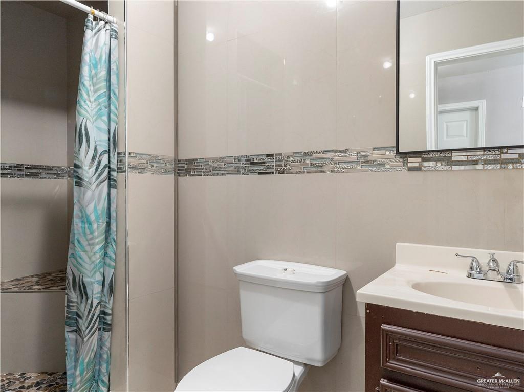 504 Benito Street Rio Grande City, TX 78582 - Photo 11 of 26 a bathroom with a sink a toilet and a mirror