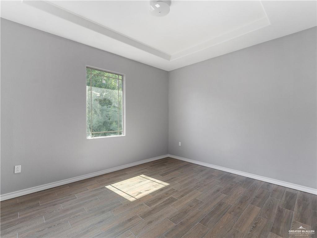 504 Benito Street Rio Grande City, TX 78582 - Photo 18 of 26 an empty room with wooden floor and windows