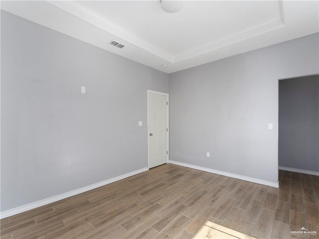 504 Benito Street Rio Grande City, TX 78582 - Photo 19 of 26 a view of an empty room with wooden floor