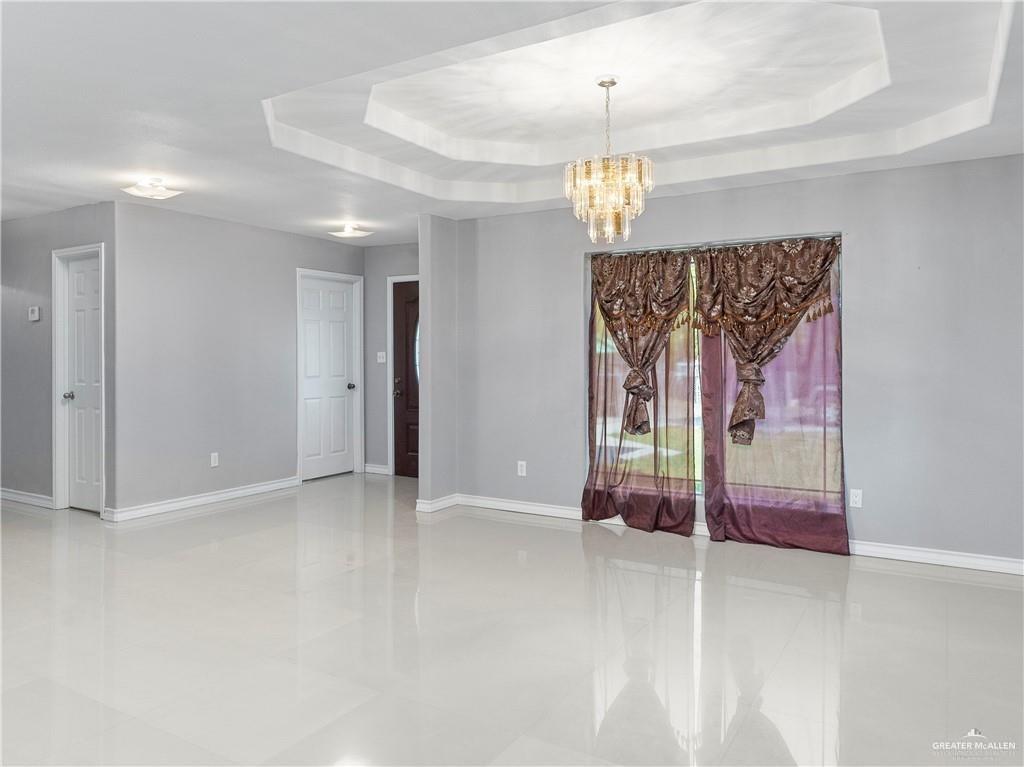 504 Benito Street Rio Grande City, TX 78582 - Photo 2 of 26 en empty room with window and a chandelier