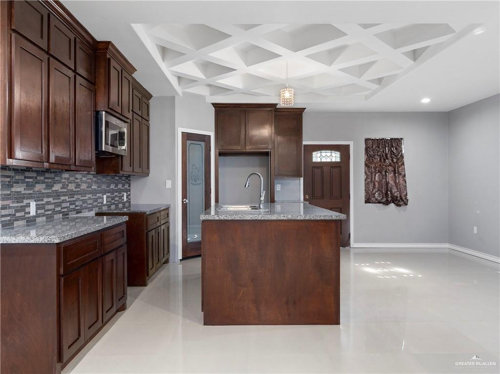 504 Benito Street Rio Grande City, TX 78582 - Photo 5 of 26 a large kitchen with stainless steel appliances a counter space a stove a sink and a refrigerator
