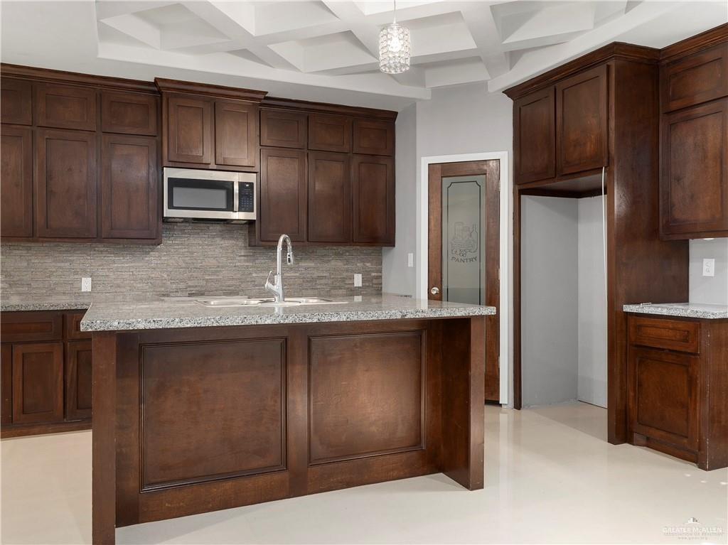 504 Benito Street Rio Grande City, TX 78582 - Photo 6 of 26 a kitchen with stainless steel appliances granite countertop wooden cabinets a refrigerator and a sink