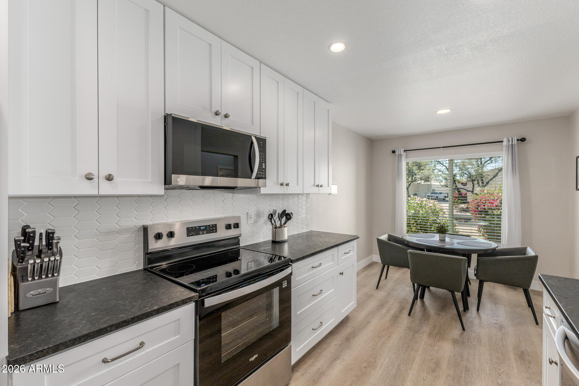 11629 North 40th Way Phoenix, AZ 85028 - Photo 16 of 47 a kitchen with stainless steel appliances granite countertop a stove a sink dishwasher and a microwave oven with white cabinets